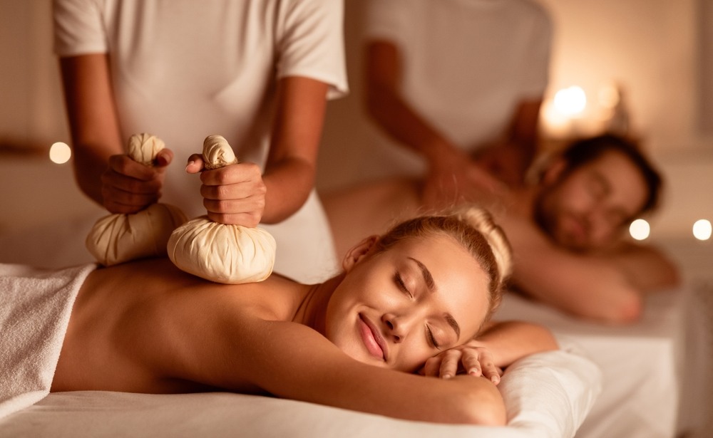 A couple enjoying a Thai herbal compress massage