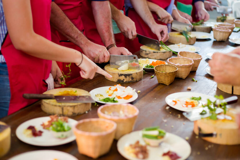Participants prepping at a Thai cooking class Participants prepping at a Thai cooking class