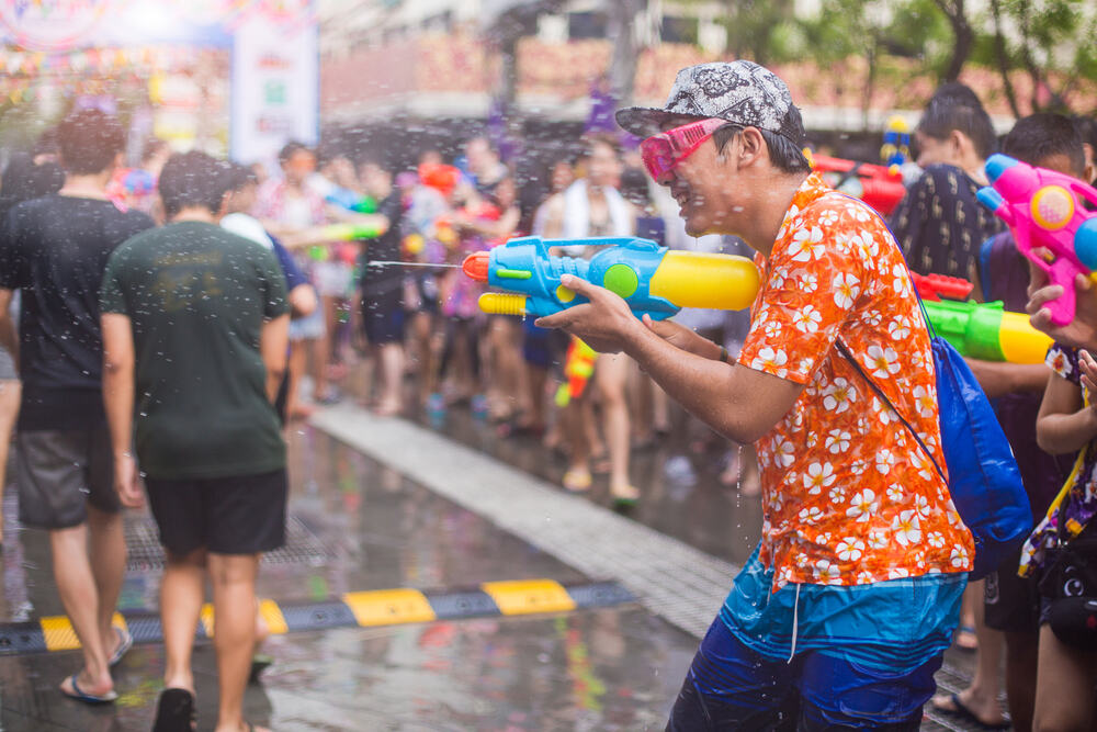A man celebrating Songkran with a water gun