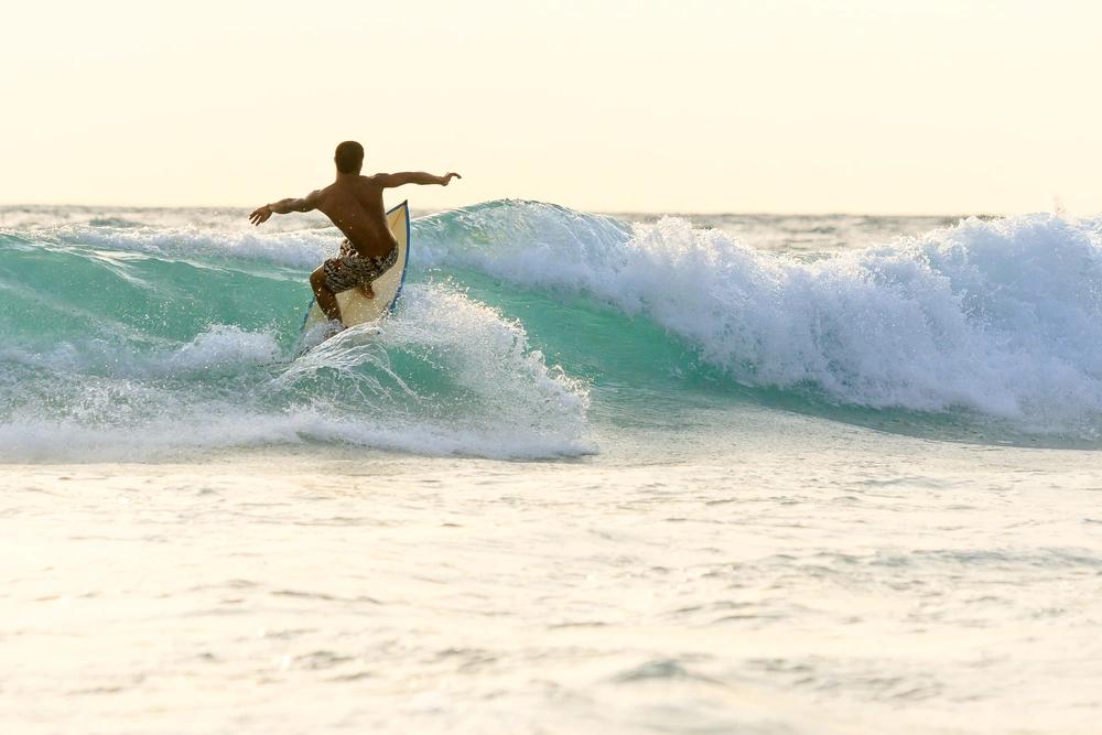 A man surfing in Phuket, Thailand, in the morning A man surfing in Phuket, Thailand, in the morning
