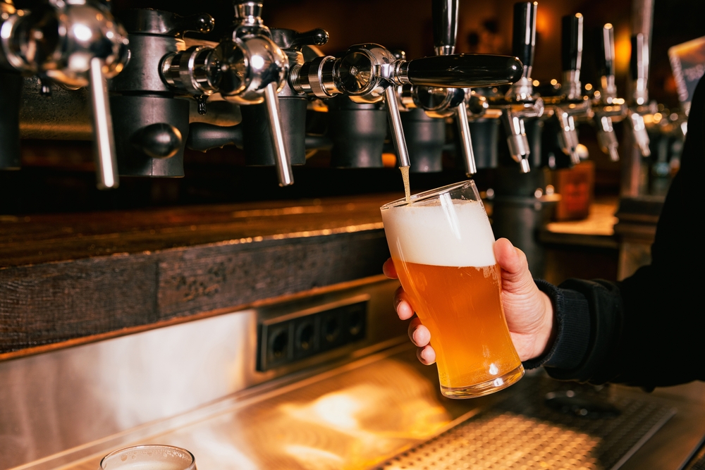 Bartender,Pouring,Light,,Cold,Foamy,Beer,From,Tap,Into,Glass Pouring craft beer on top into a glass