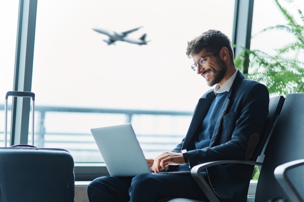 A man working on his laptop at the airport A man working on his laptop at the airport