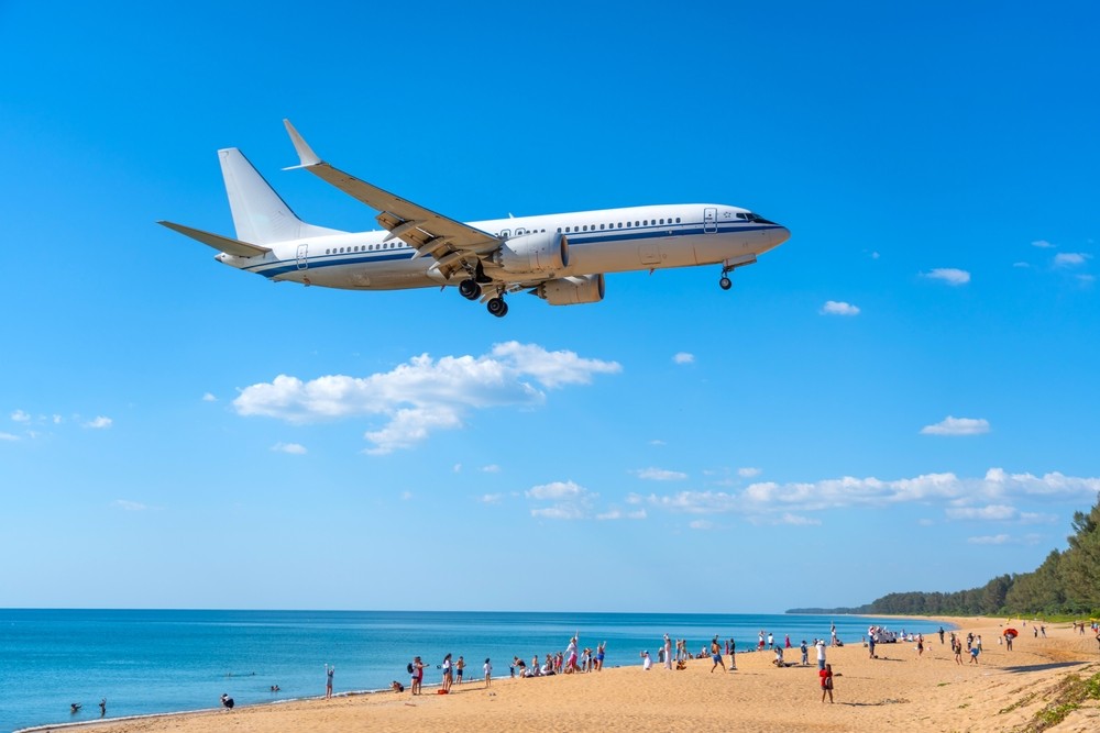 An airplane flying over a beach An airplane flying over a beach